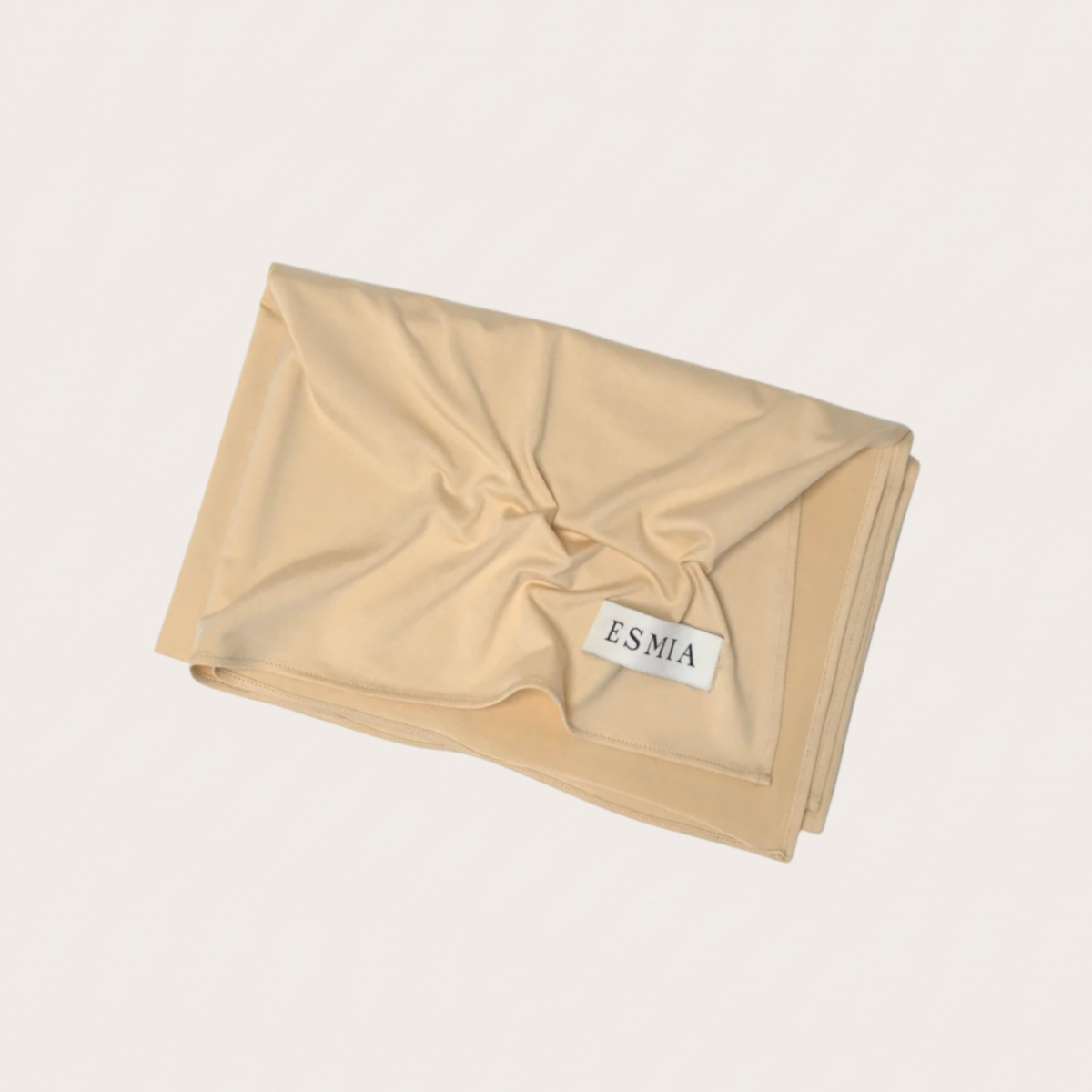 L'Étole ESMIA coloris Aurore, hijab beige nude présenté plié et drapé, étiquette ESMIA