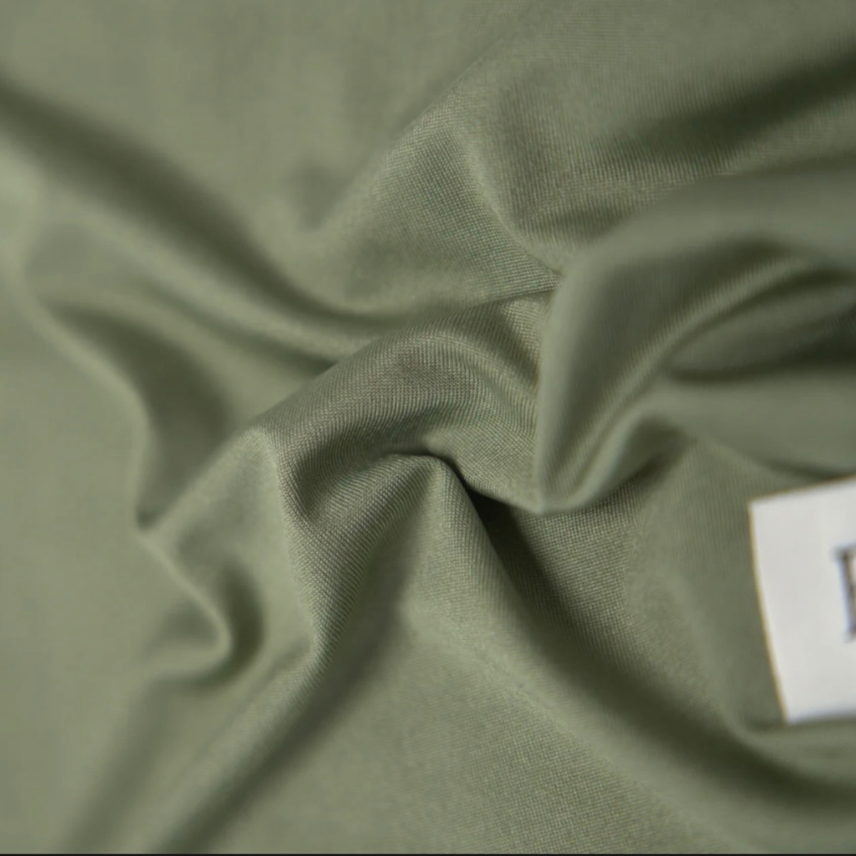 Gros plan sur la matière fluide de L'Étole ESMIA en coloris Cèdre, hijab vert