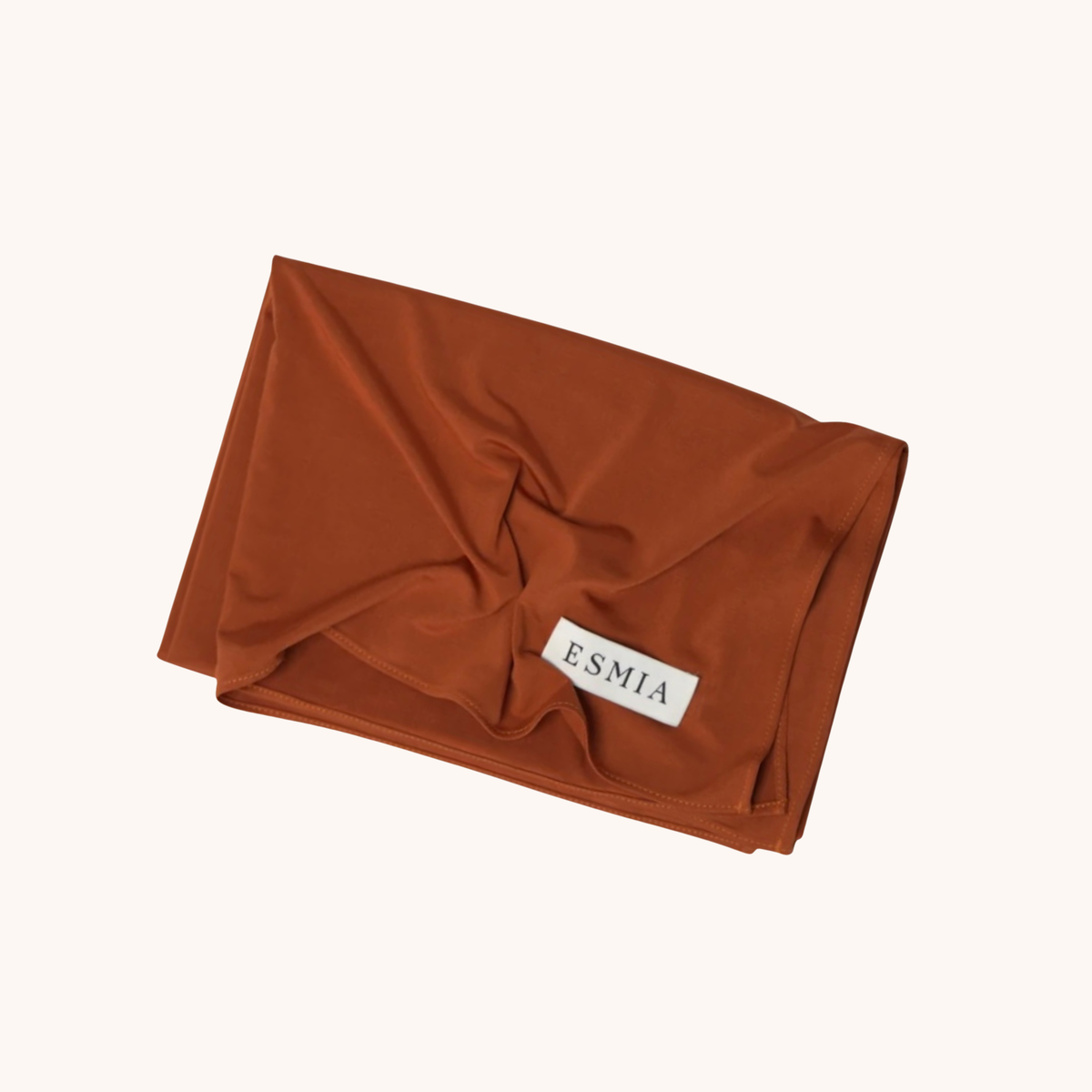 L'Étole ESMIA coloris Sienne, hijab terracotta présenté plié et drapé, étiquette ESMIA